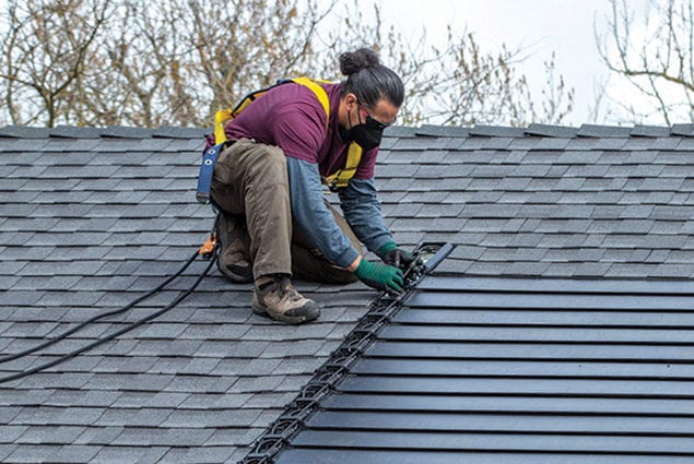 Worker installing Timberline Solar on Roof